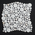 Mosaic tile with circular white stones on a black background