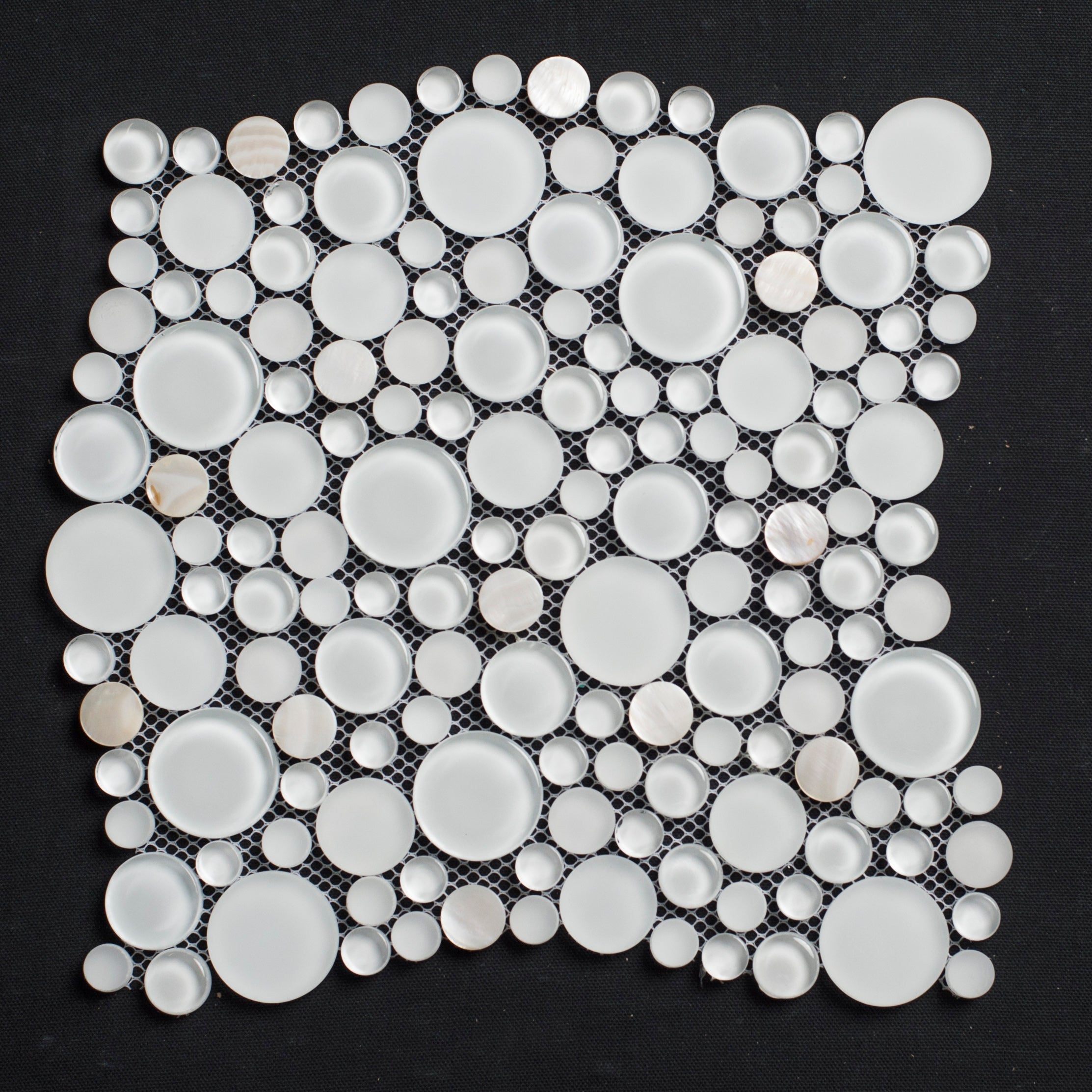 Mosaic tile with circular white stones on a black background