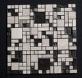 Mosaic pattern of black, white, and gray tiles on a dark background