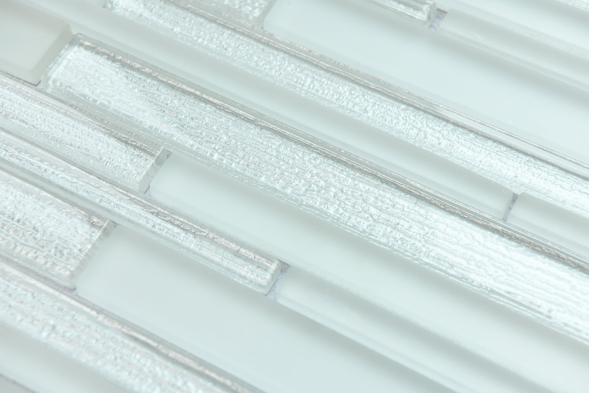 Close-up of light gray glass mosaic tiles with a subtle pattern