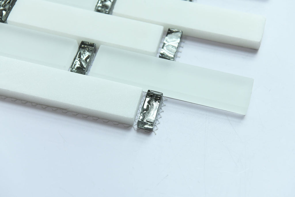 Close-up of white rectangular tiles with metallic clips on a light gray background