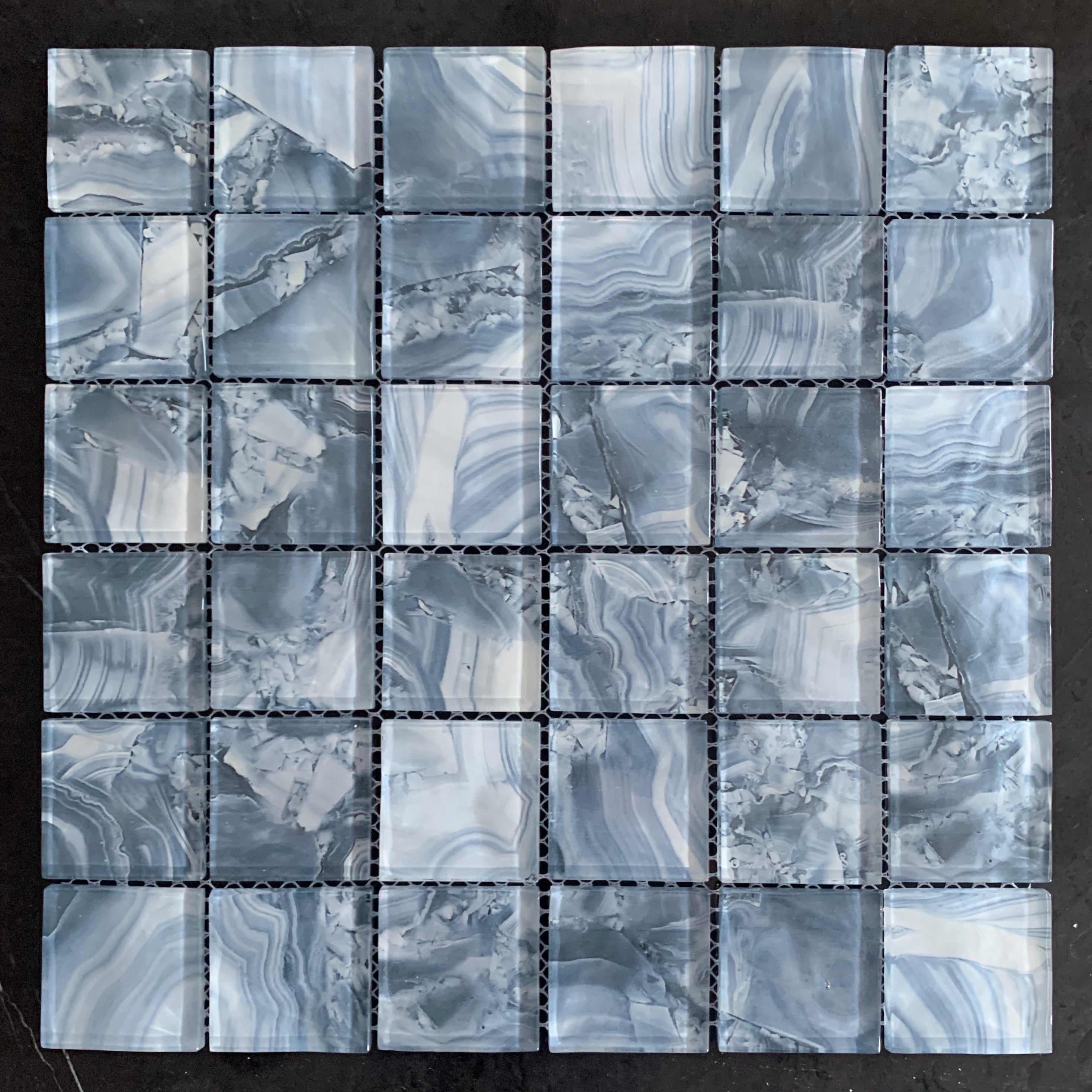 Mosaic tile pattern with gray and white marbled design on a black background